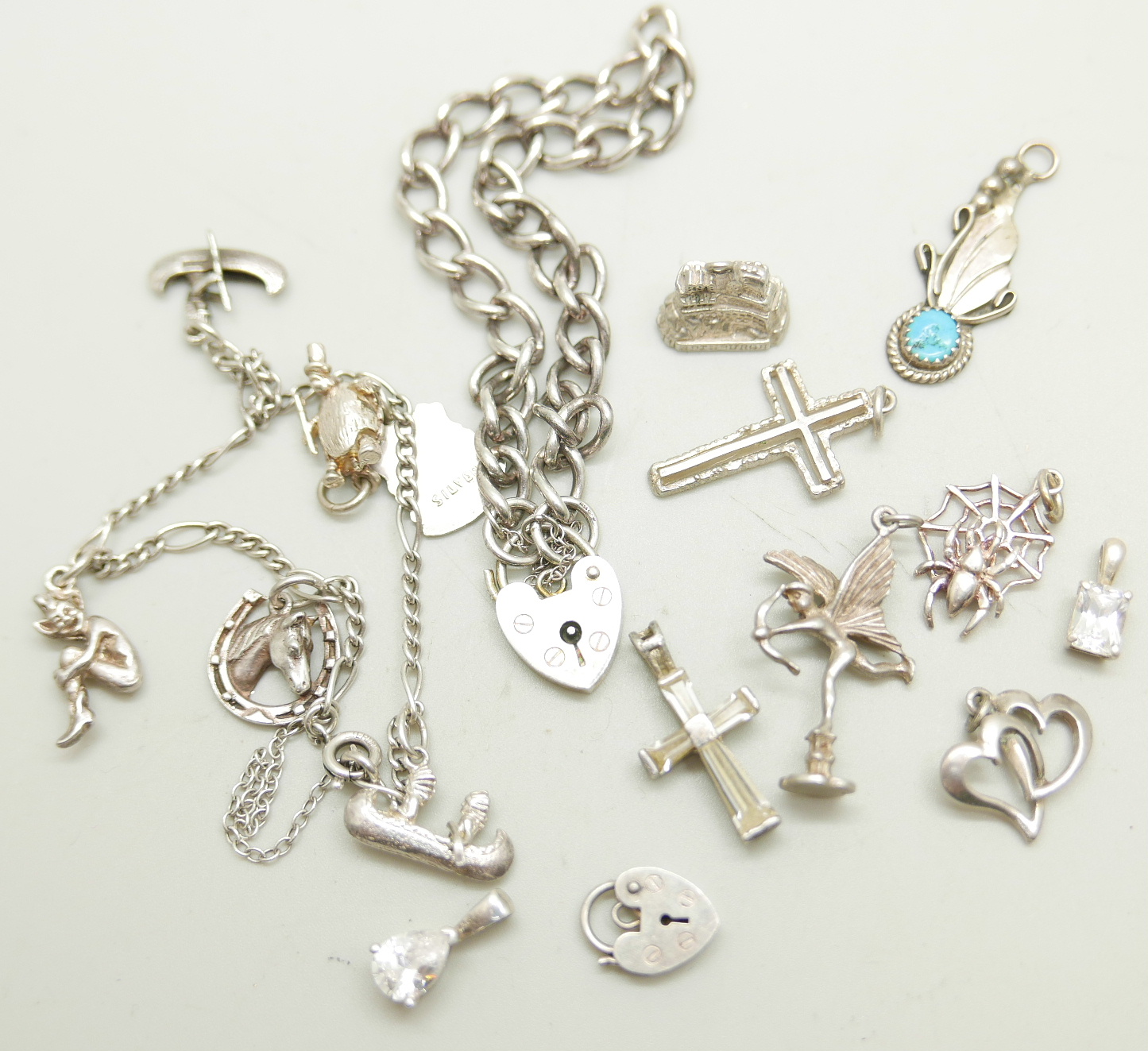 A silver charm bracelet, loose charms and a silver padlock bracelet, 42g