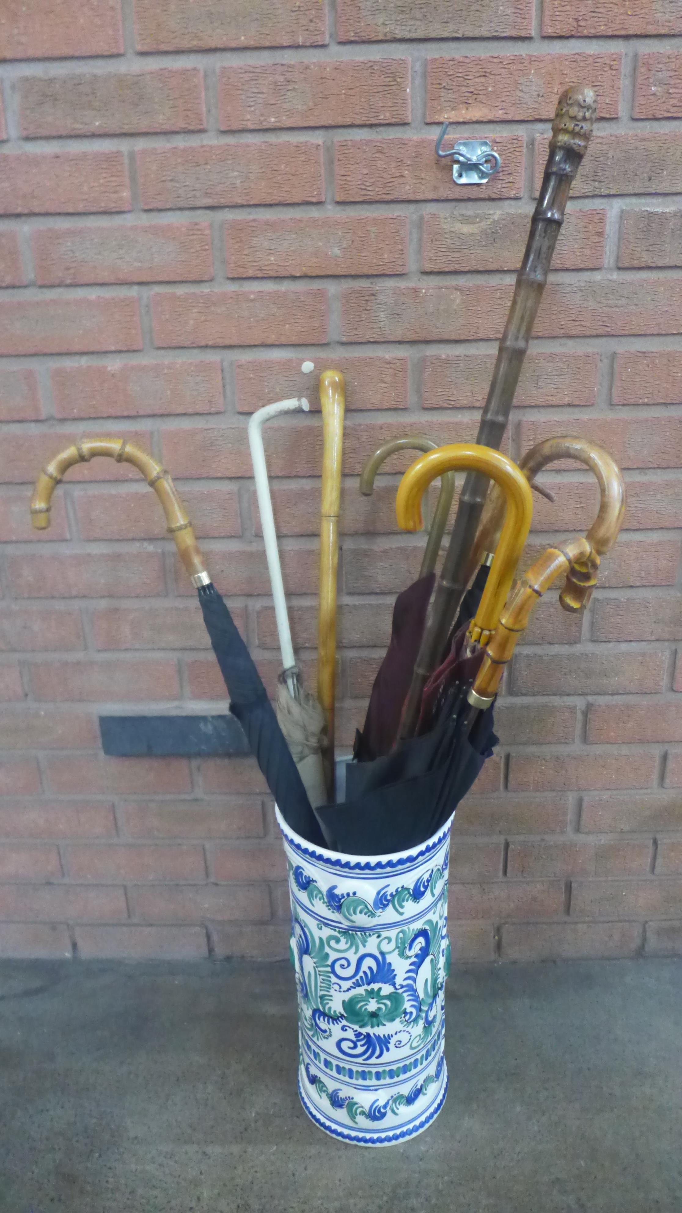 A ceramic stick stand with a collection of six umbrellas, and three walking sticks **PLEASE NOTE