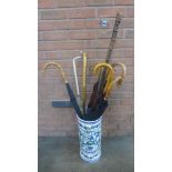 A ceramic stick stand with a collection of six umbrellas, and three walking sticks **PLEASE NOTE