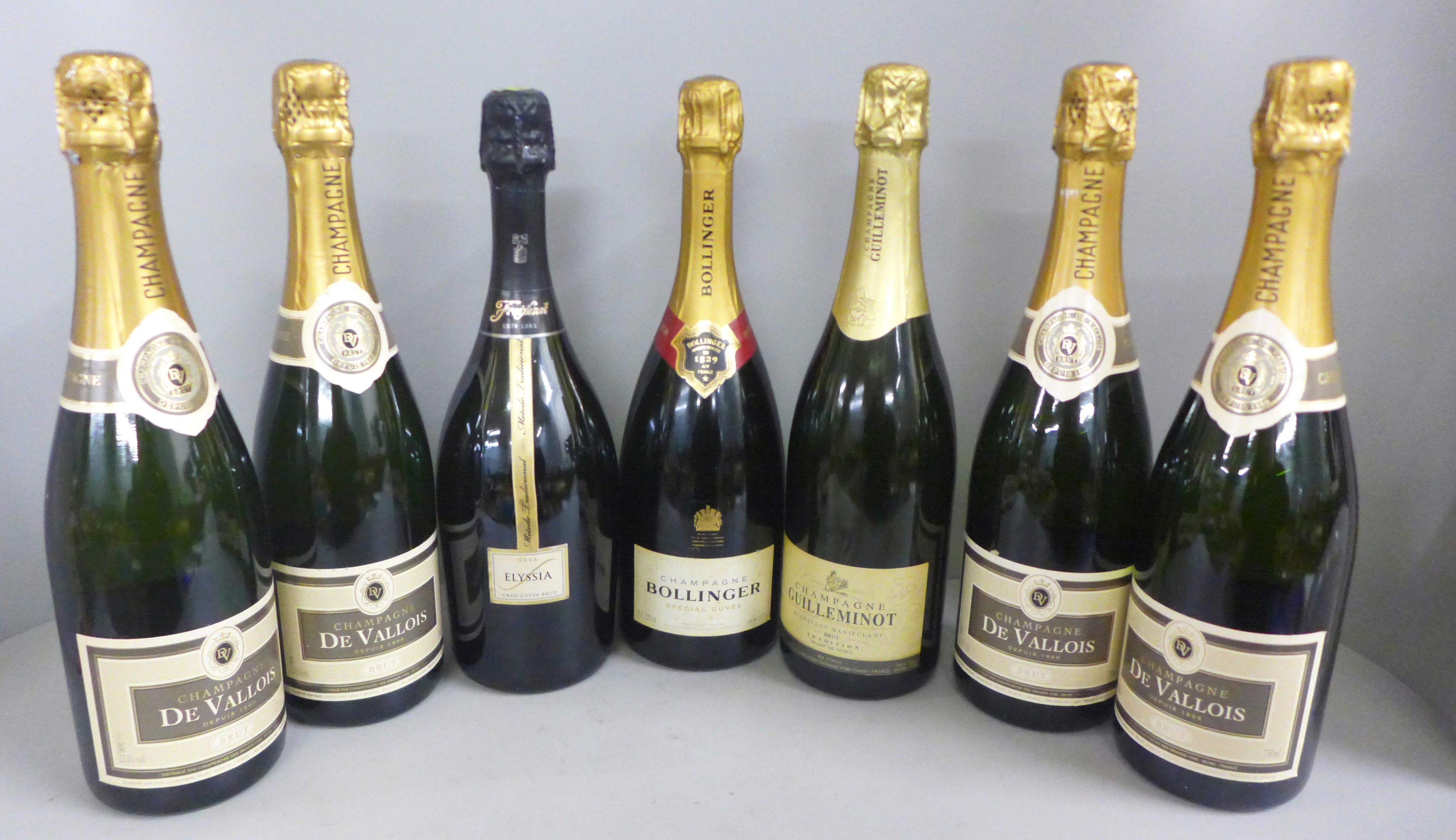 Seven bottles: four De Vallois Champagne, one Bollinger Champagne Special Cuvee and two others