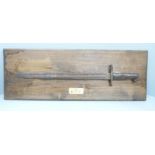 A bayonet, mounted on a wooden plaque, marked 'found Meuse Argonne Sector France'