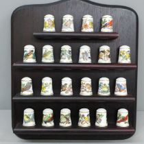 A Franklin Mint set of thimbles, Songbirds of the World, 22 thimbles on a wooden stand