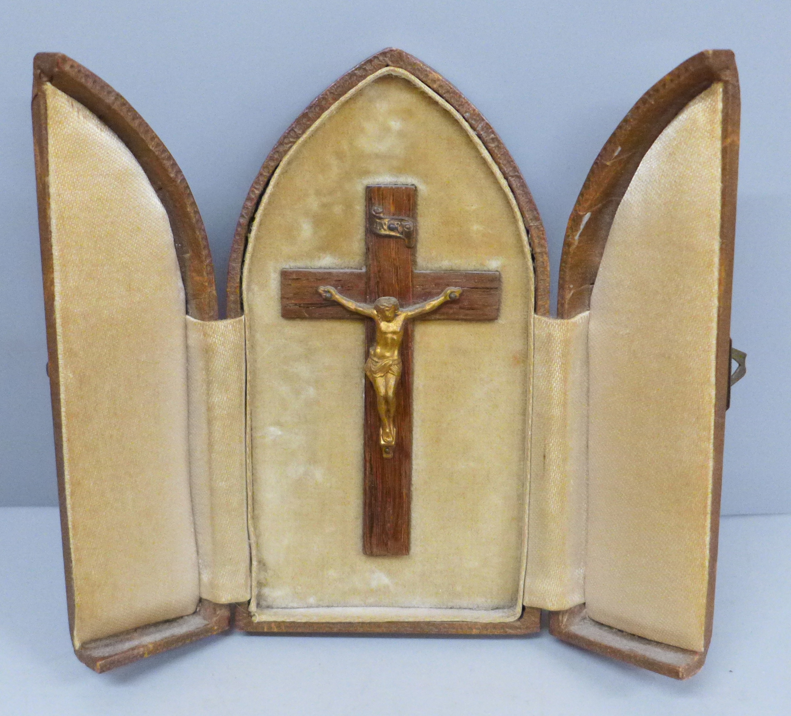 A travelling crucifix shrine in a faux leather tri-fold case
