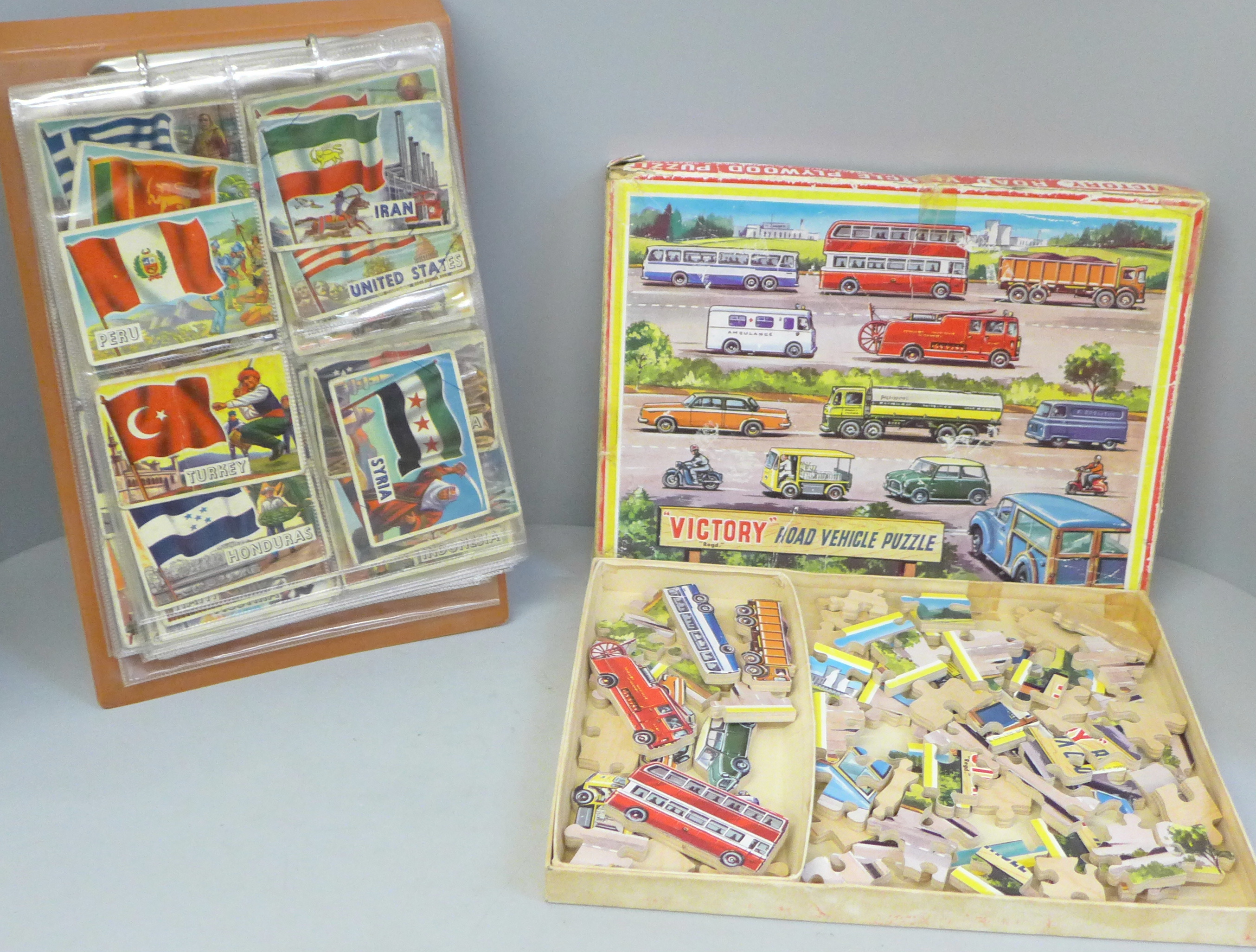 A collection of A&BC Flags of The World Collectors cards and a Victory Road Vehicle puzzle
