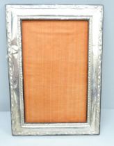 A large silver photograph frame, dented and back stand requires repair, 24cm wide