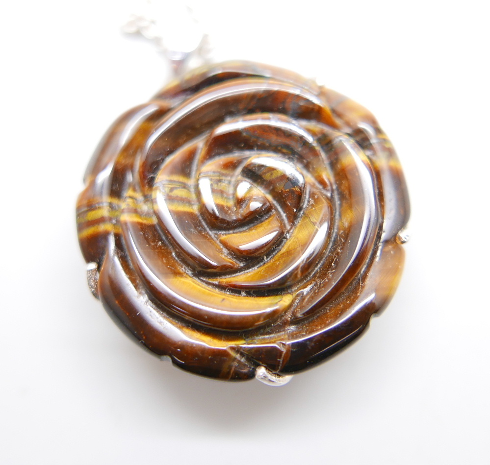 A carved silver mounted tigers eye pendant on a silver chain and a pair of tigers eye earrings, - Bild 2 aus 3