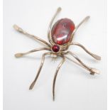 A large plated silver spider brooch, set with agate, faceted garnet and pearl eyes