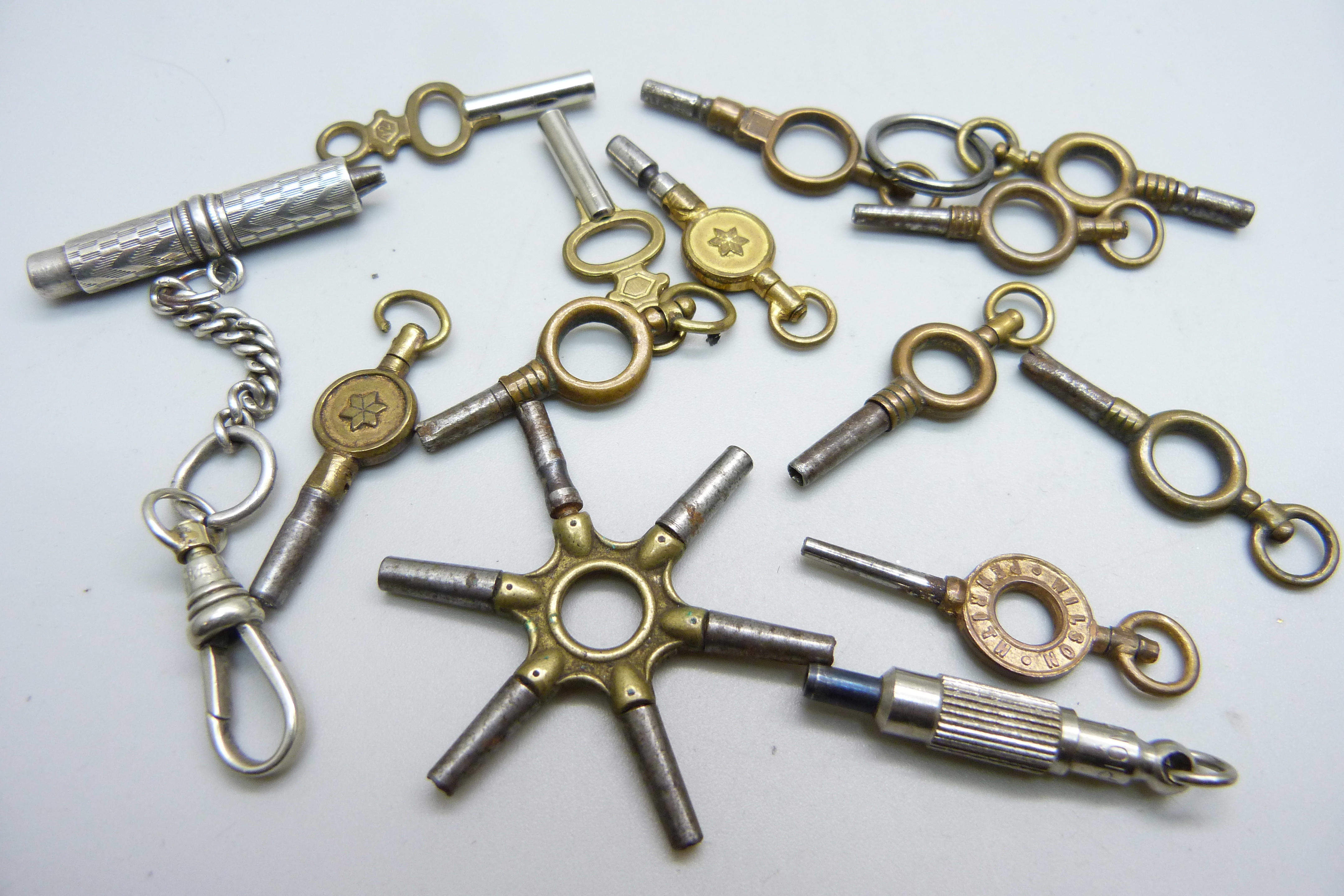 A collection of watch keys including a silver universal bench key on a silver chain and advertising