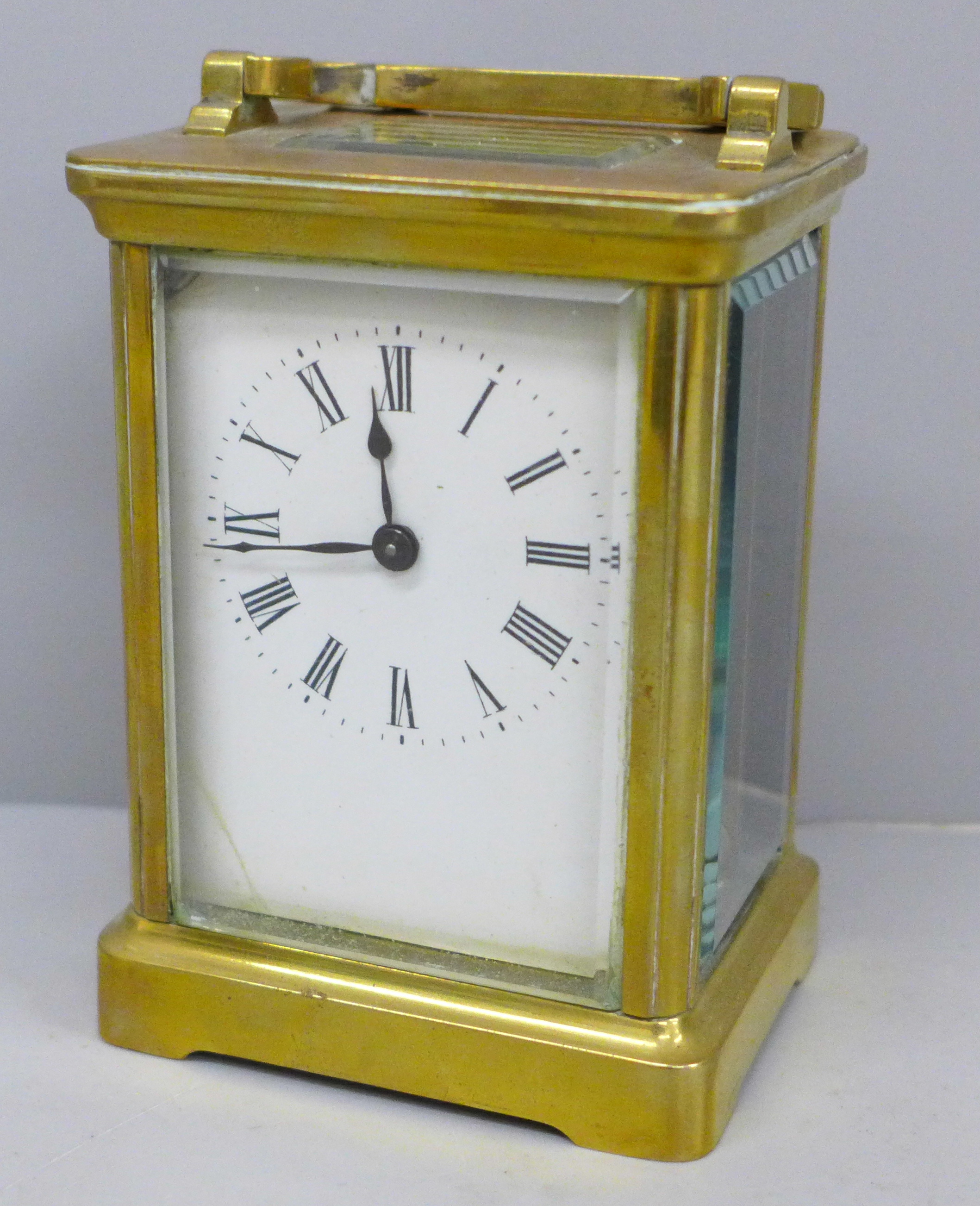 A French brass and four glass sided carriage clock with key