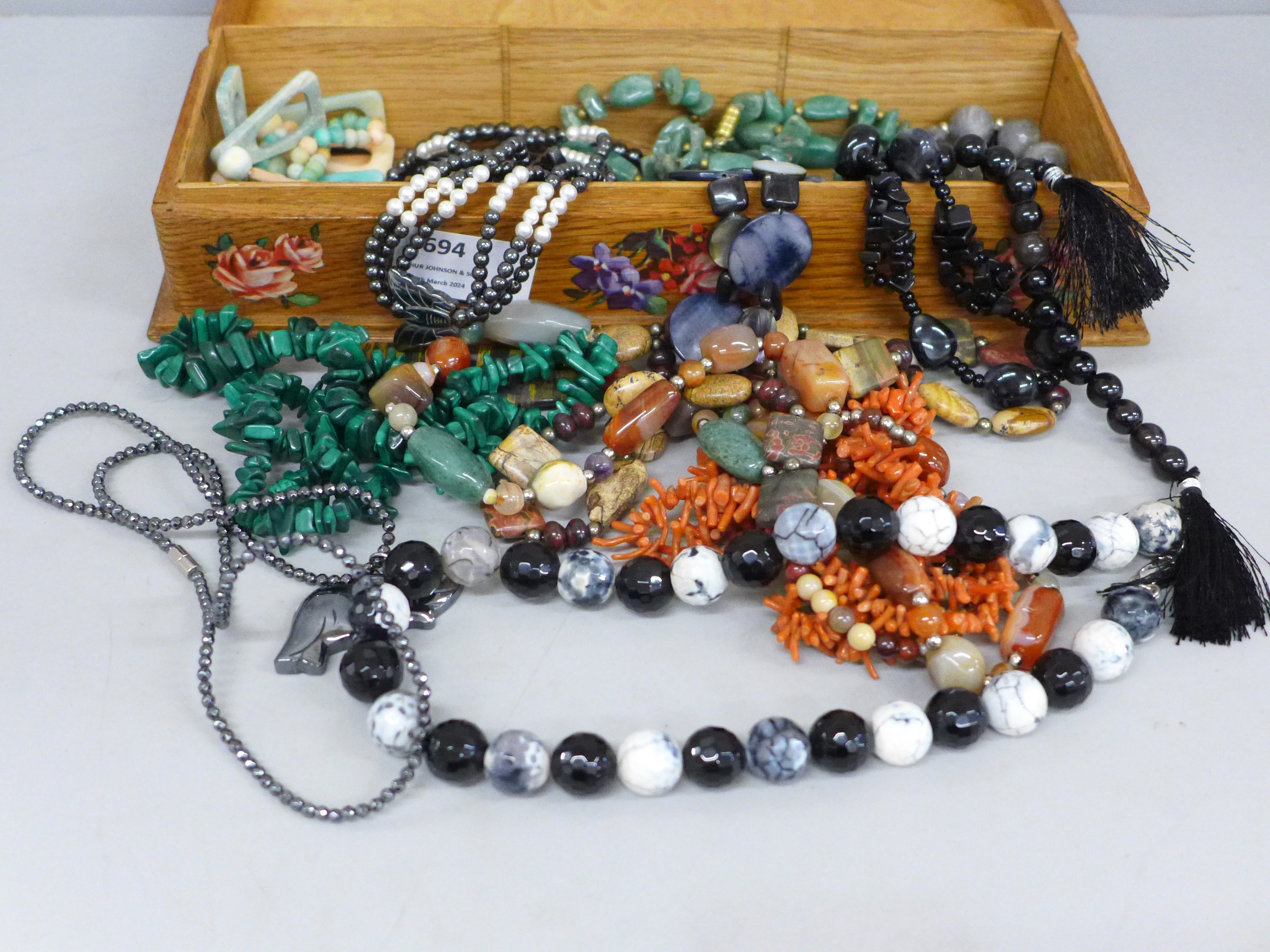 A collection of necklaces, labradorite, coral, Scottish pebble, malachite, in wooden box decorated