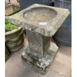 A concrete garden bird bath