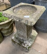 A concrete garden bird bath