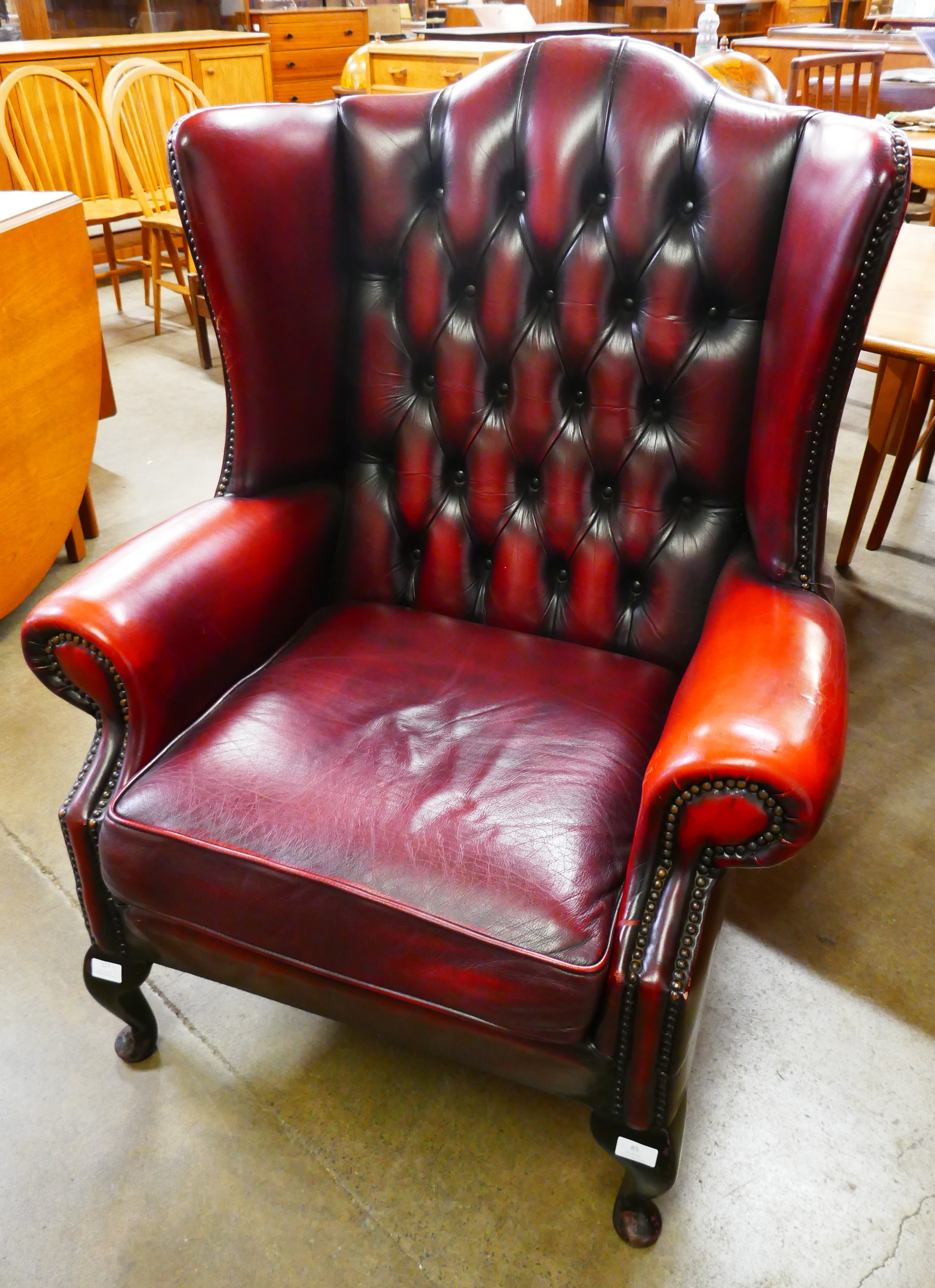 An oxblood red leather Chesterfield wingback armchair