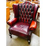 An oxblood red leather Chesterfield wingback armchair