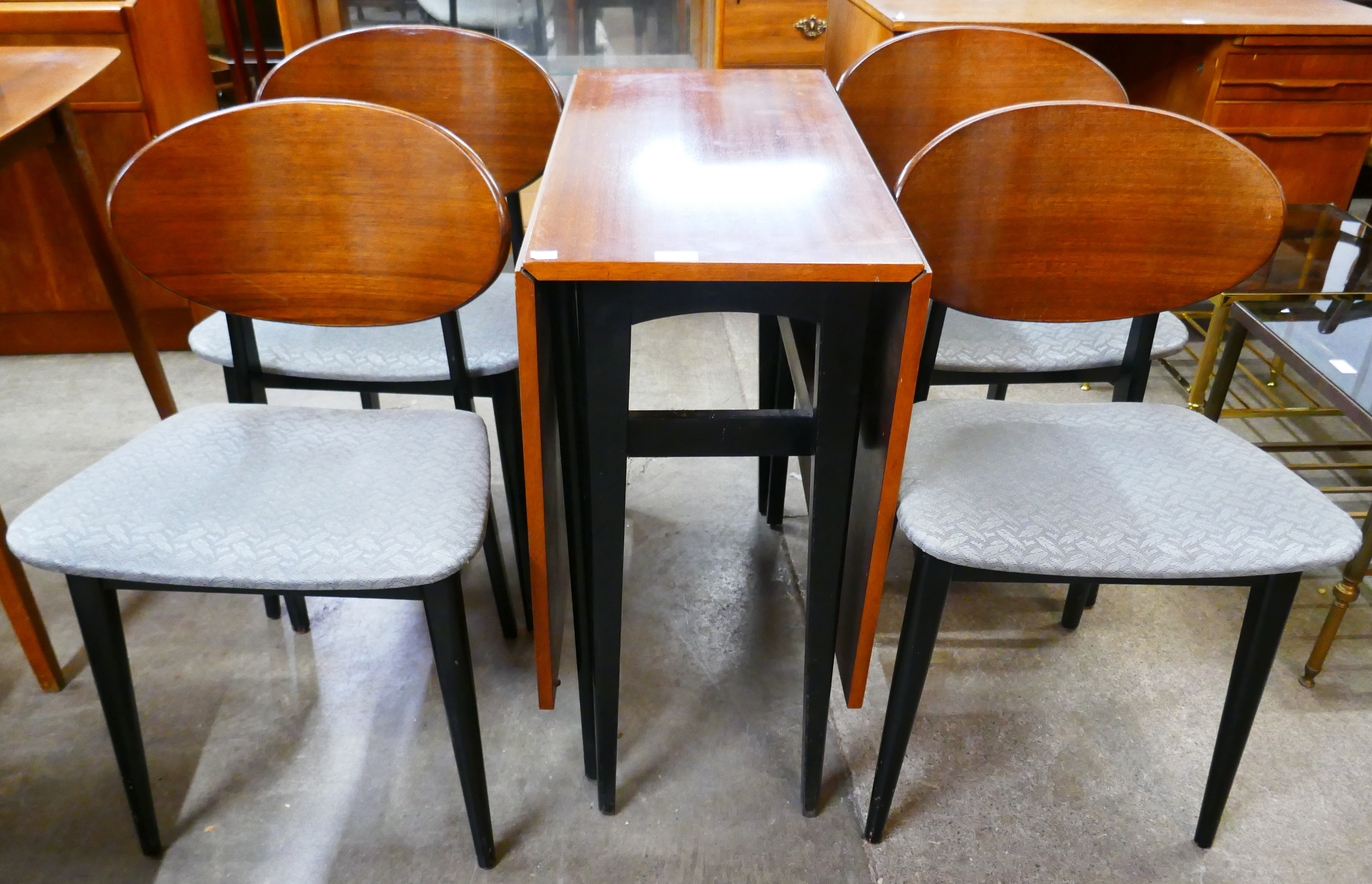 A G-Plan Librenza tola wood and black drop-leaf table and four chairs