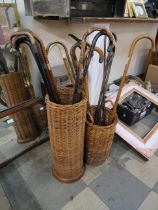 A wicker stick stand with eight walking sticks (seven with silver collars/embellishments) and an