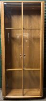 A tall Ercol Blonde ash display cabinet