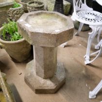 A concrete garden bird bath