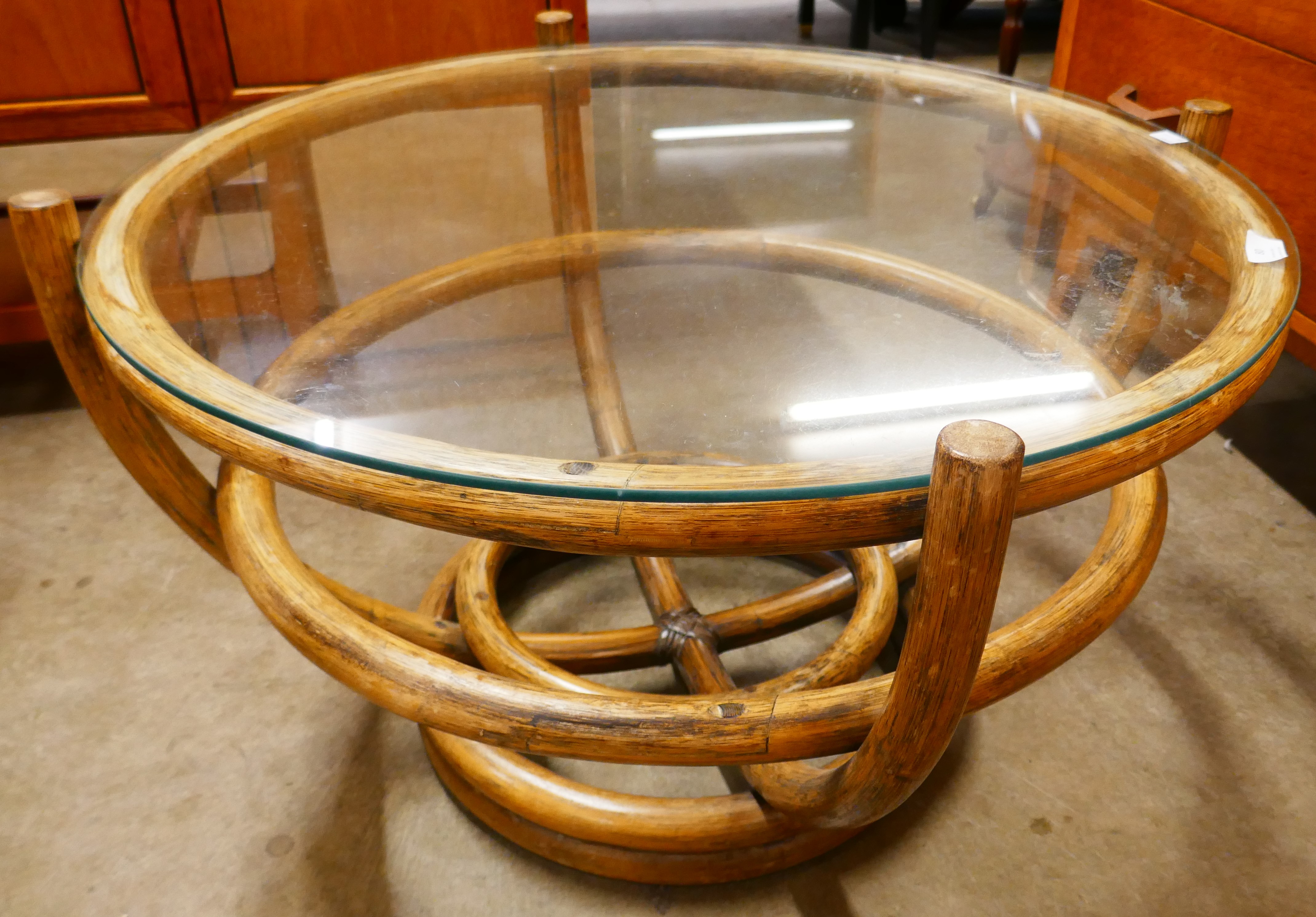 A circular bamboo and glass topped coffee table