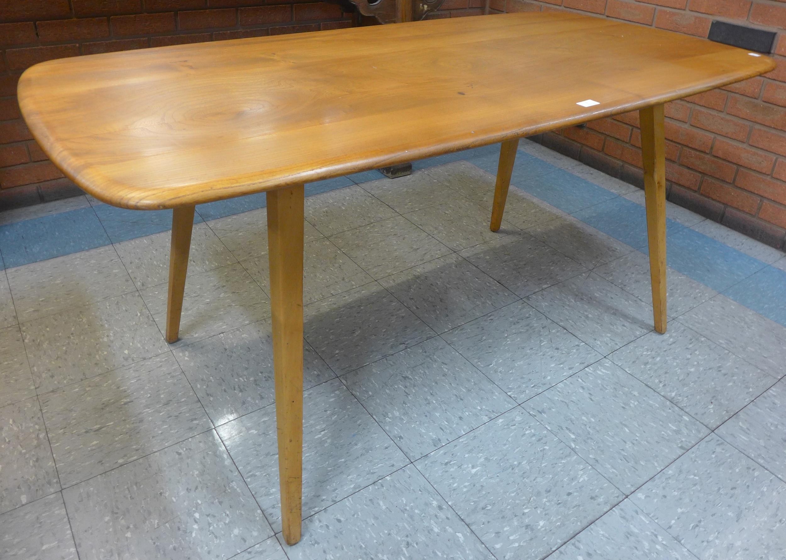 An Ercol Blonde elm and beech plank top Windsor dining table