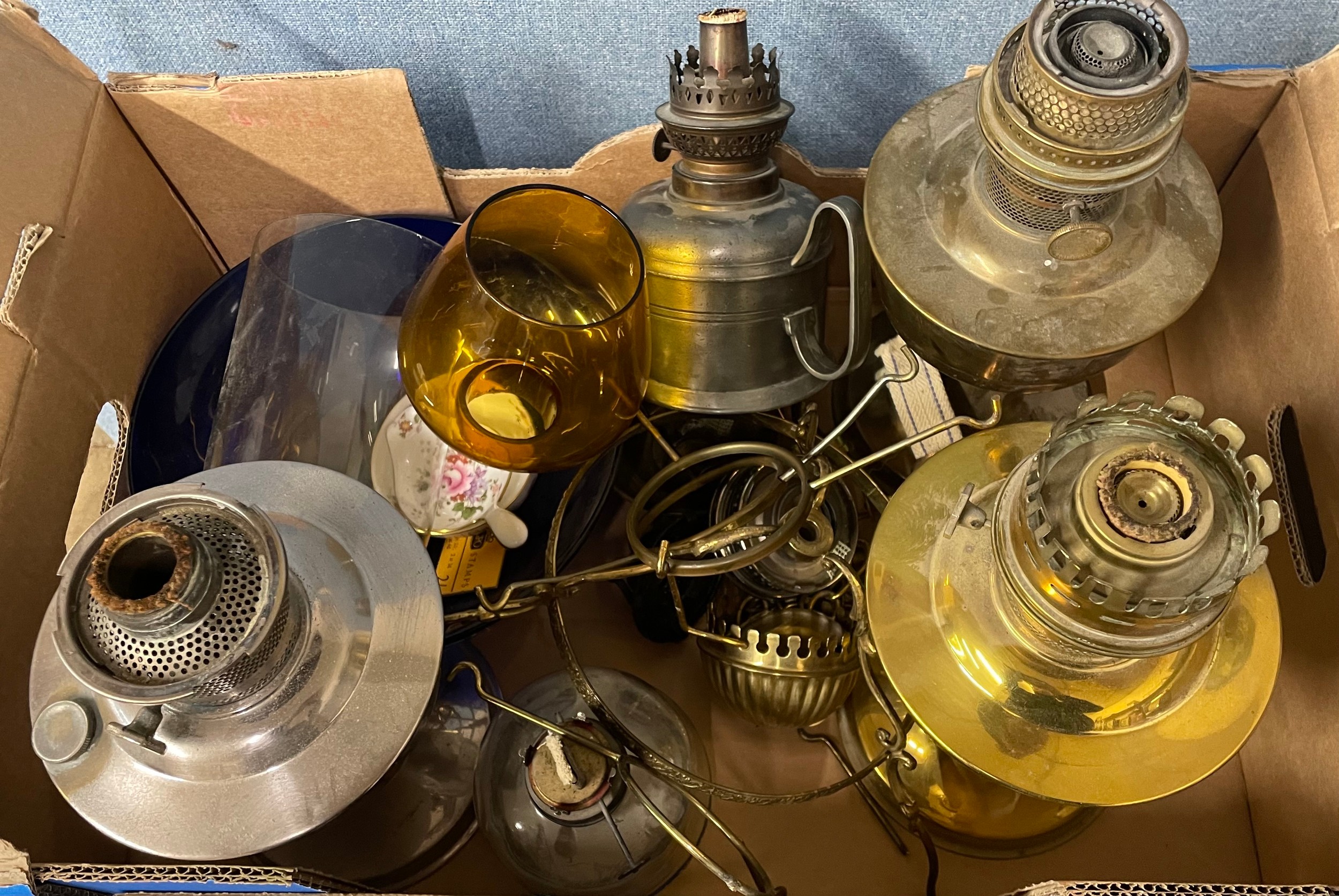 Two oil lamps and a box of oil lamp bases and parts