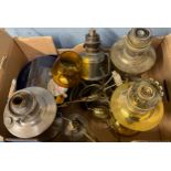 Two oil lamps and a box of oil lamp bases and parts