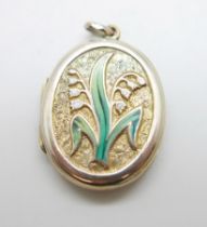 A locket with applied gold and enamelled detail, 22mm wide, marked 9ct