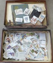 A suitcase containing a collection of cigarette cards including Players, Ogdens and Wills
