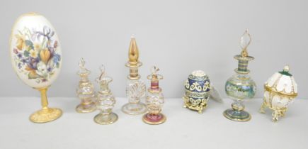 Five glass perfume bottles, three enamelled and decorated brass eggs with hinged lids and one