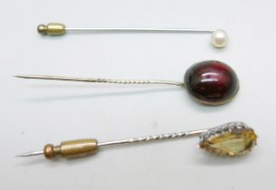 Three stick pins, cabochon garnet, citrine and pearl set