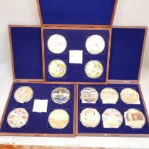 A presentation box of four large coins, Queen Elizabeth II banknotes, a box of Centenary WWI