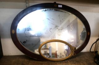 An inlaid mahogany oval mirror and a small gilt framed mirror