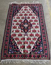 A pink, blue and white floral patterned rug 173 x 110cms