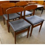 A set of four teak and black vinyl dining chairs