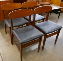A set of four teak and black vinyl dining chairs