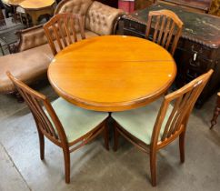 A Stag teak circular extending dining table and four chairs