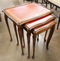 A mahogany and red leather topped nest of tables