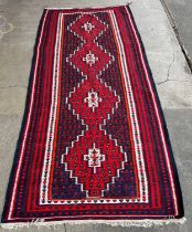 A large red and navy blue ground rug 314 x 144cms