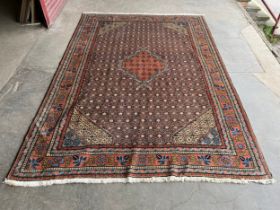 An Eastern terracotta and blue ground rug 295 x 208cms