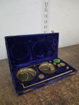 A cased set of brass postal scales and graduated weights