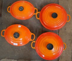 Four Le Creuset volcanic orange cooking pots