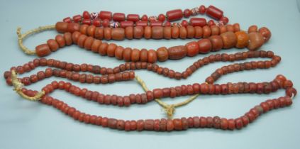 Four coral coloured necklaces