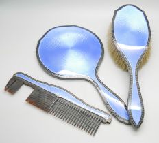 A silver and blue enamelled hand mirror with black enamelled border and with matching brush and comb