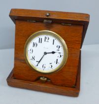 A wooden cased travel clock with 8 days movement