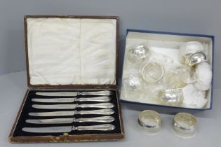A cased set of six silver handled knives and a collection of plated napkin rings
