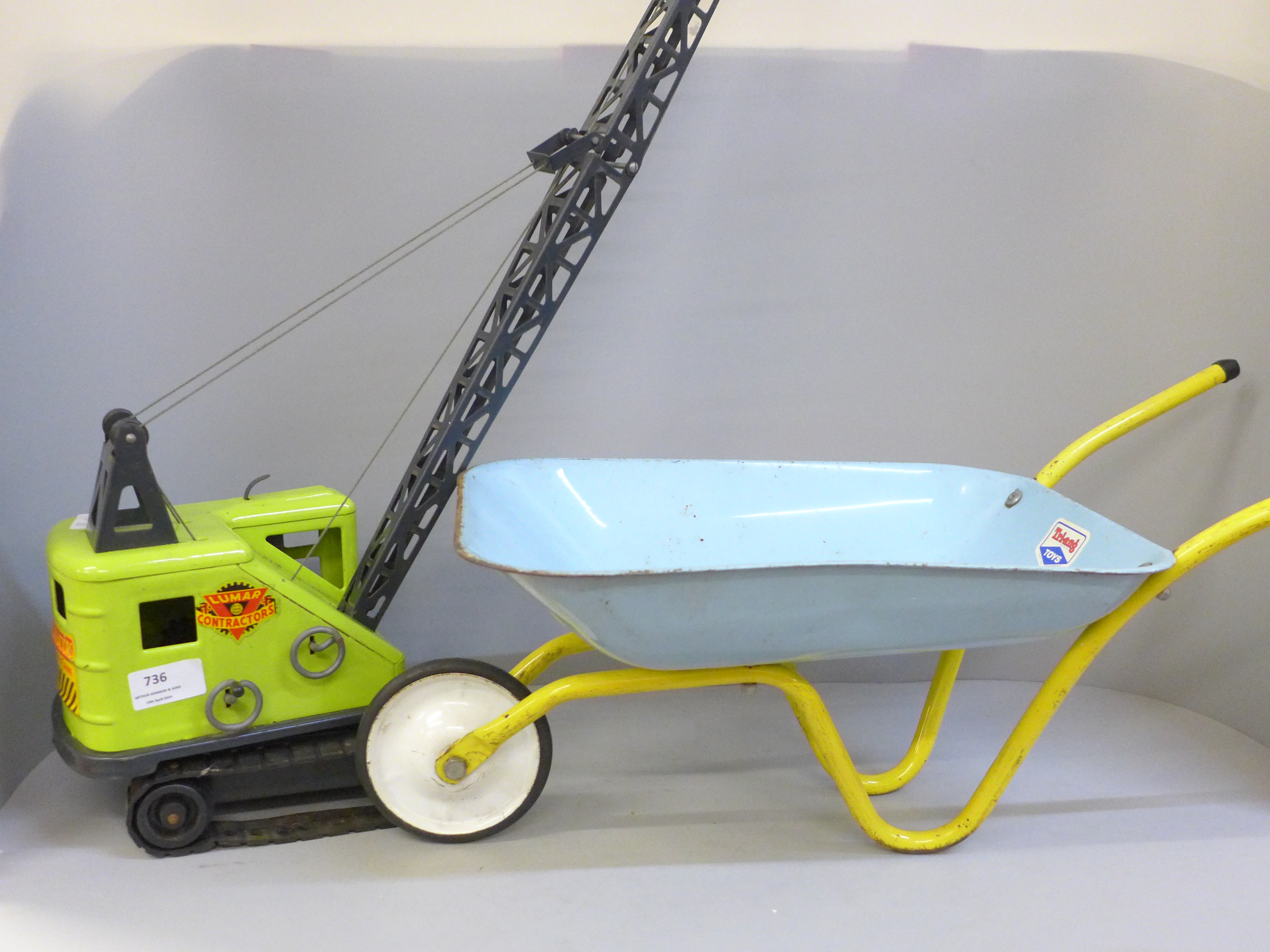 Two pressed metal toys, a Lumar crane and a Tri-ang wheelbarrow