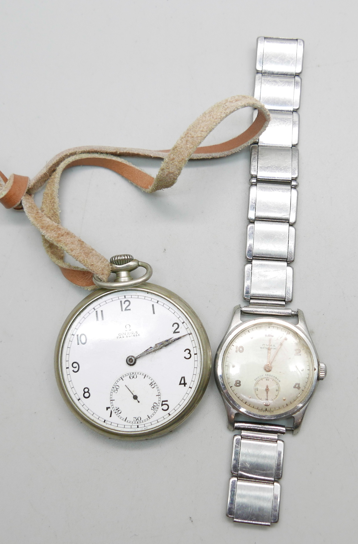 A Cyma Watersport wristwatch and an Omega top wind pocket watch, lacking glass