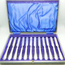 A cased set of twelve dessert knives, with silver covered handles