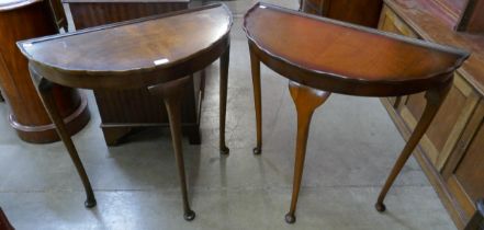 A pair of walnut demi-lune hall tables