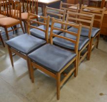 A set of six teak and black vinyl chairs